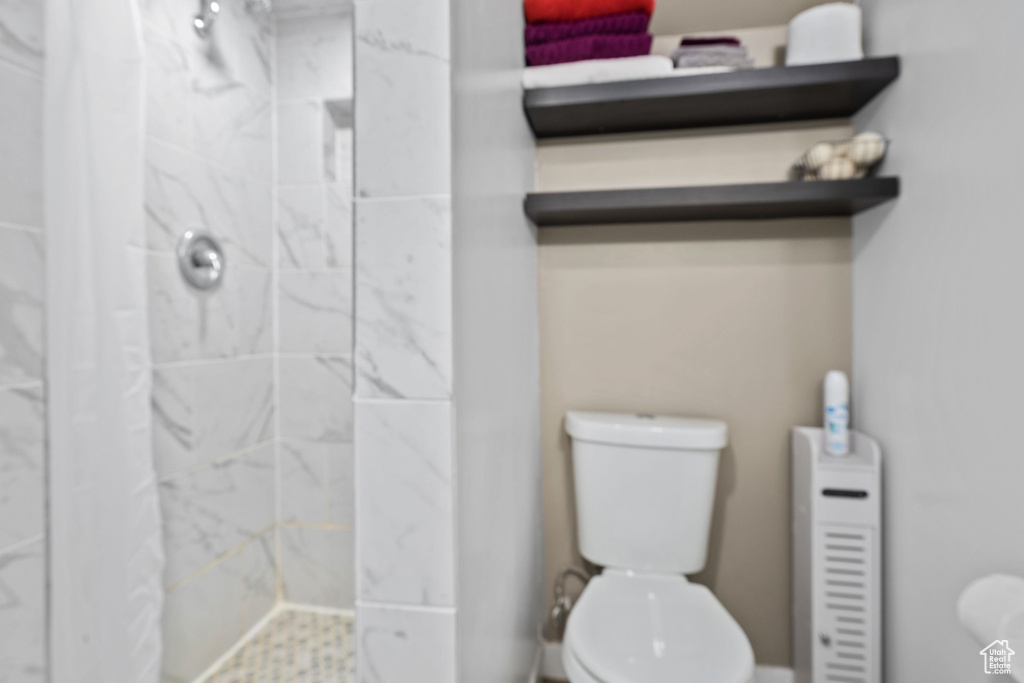 Bathroom with a marble finish shower and toilet