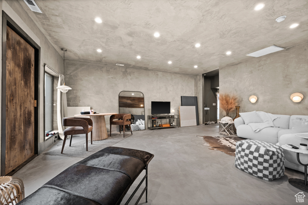 Living area featuring finished concrete floors and recessed lighting