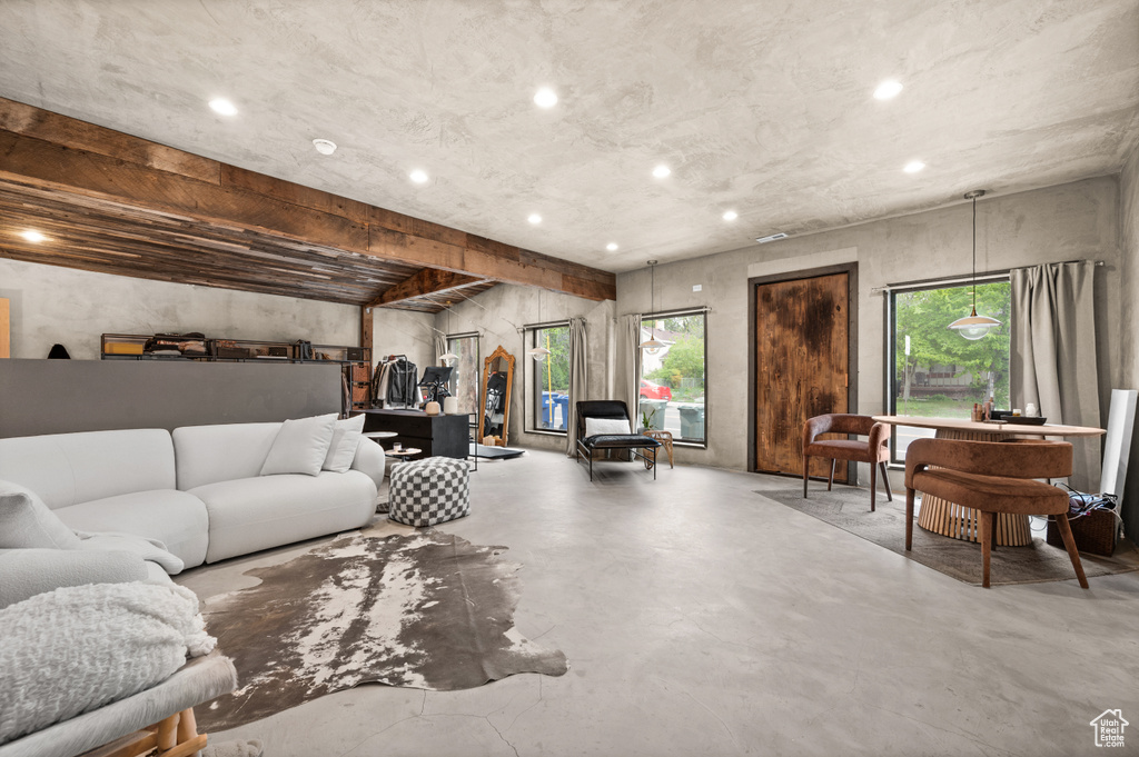Living room featuring healthy amount of natural light, finished concrete flooring, and recessed lighting