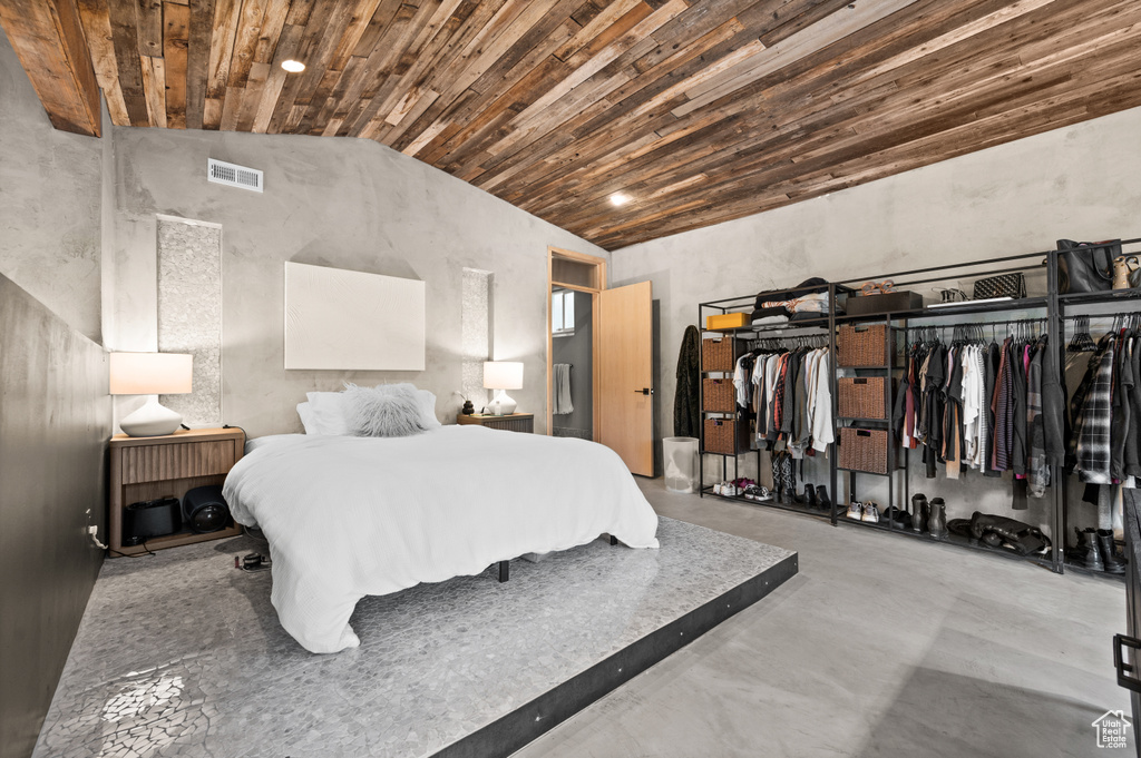 Bedroom featuring wooden ceiling, concrete floors, and recessed lighting