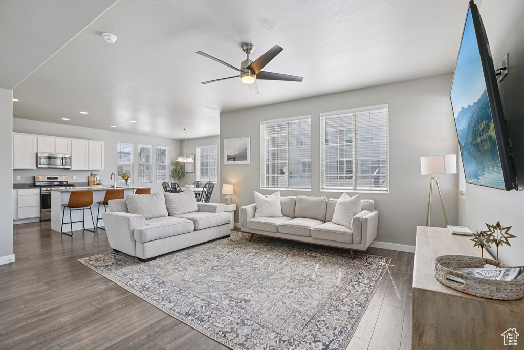 Living area featuring dark wood-style flooring, ceiling fan, recessed lighting, and baseboards