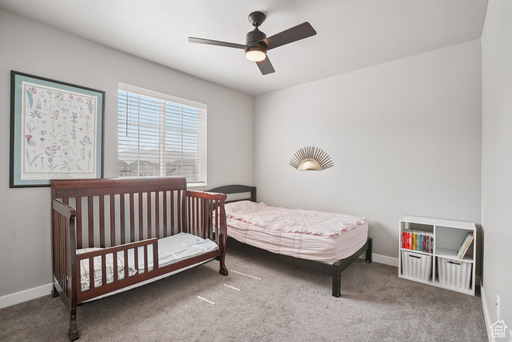 Carpeted bedroom featuring baseboards and a ceiling fan
