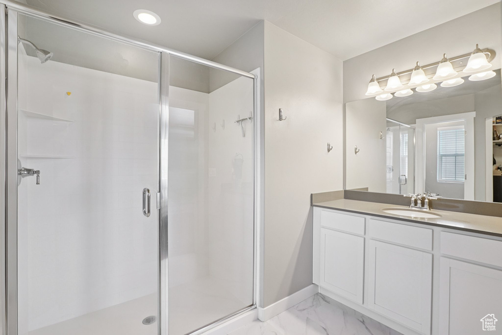 Bathroom with a stall shower, vanity, marble finish flooring, recessed lighting, and baseboards