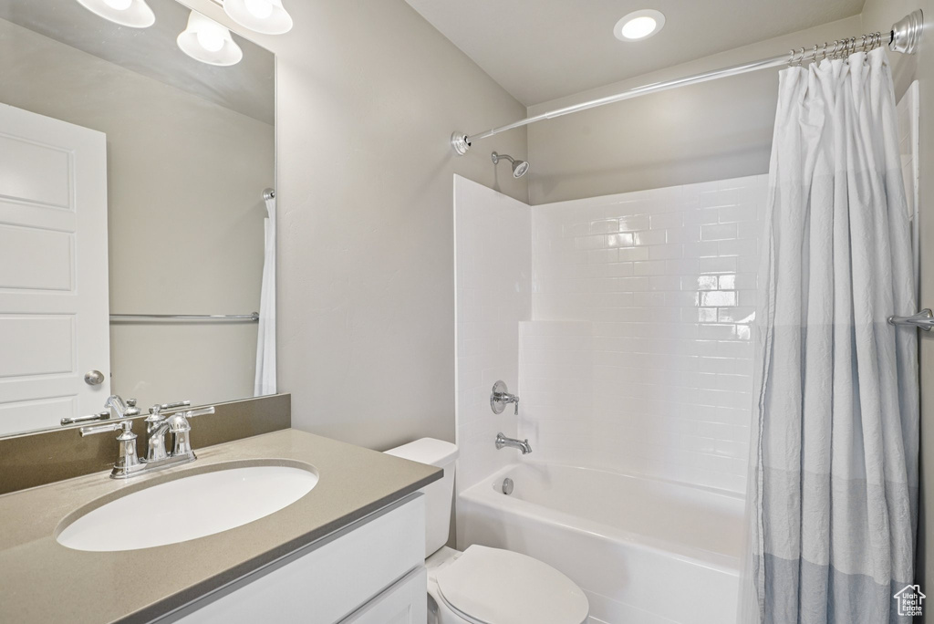 Bathroom featuring shower / bath combo, vanity, toilet, and recessed lighting