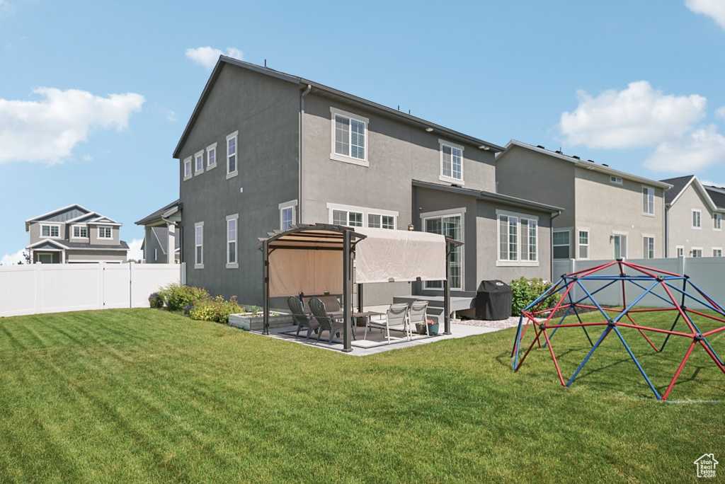 Rear view of property featuring a patio, stucco siding, and a residential view