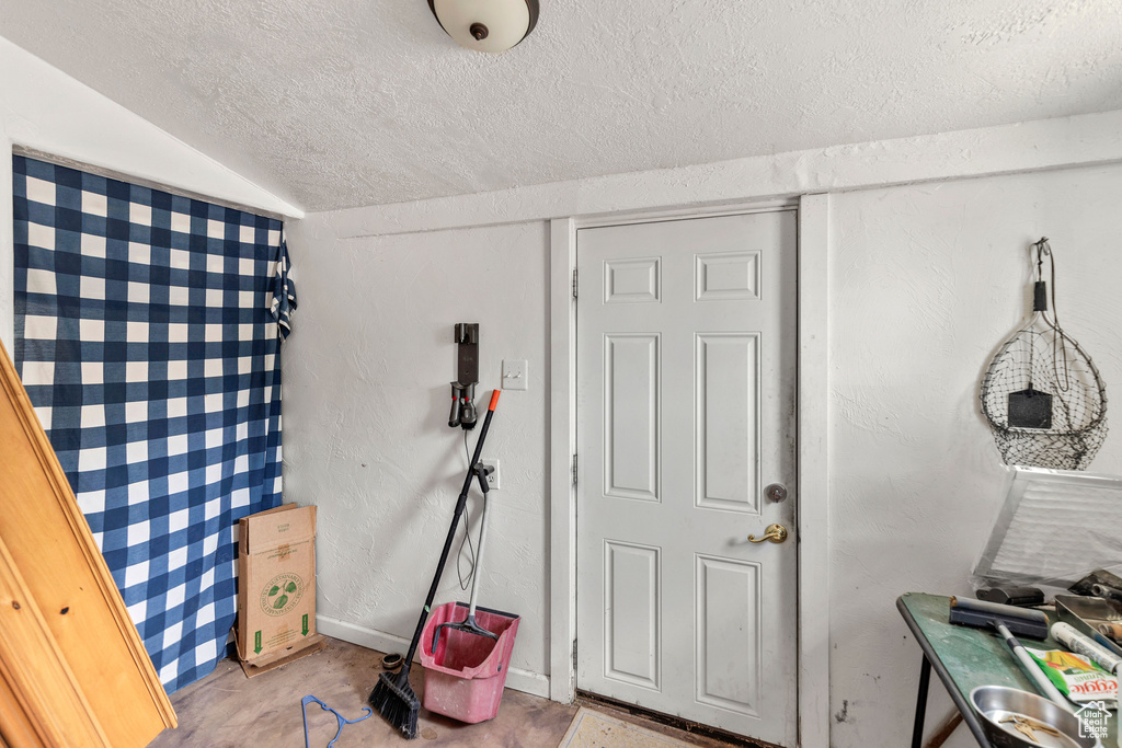 Miscellaneous room with a textured ceiling and concrete floors