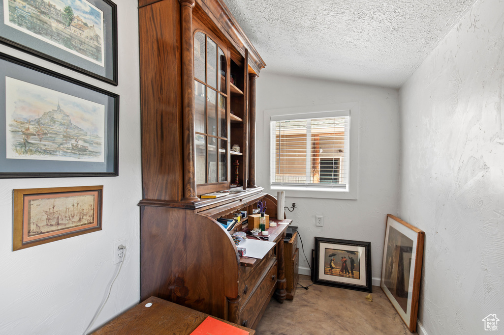 Office space with lofted ceiling and a textured ceiling