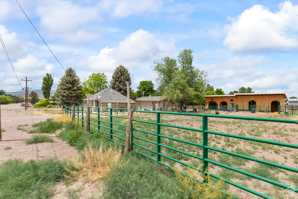 View of yard featuring an exterior structure, an outdoor structure, and a rural view