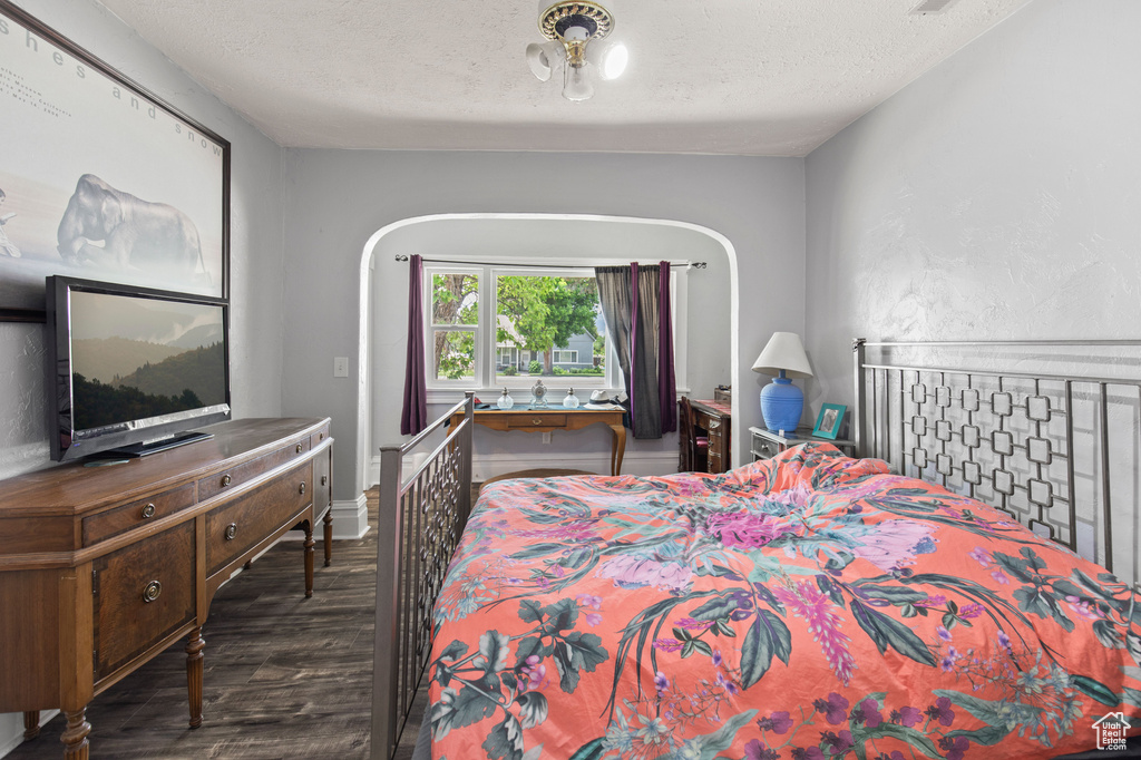 Bedroom with dark wood-type flooring and a textured ceiling