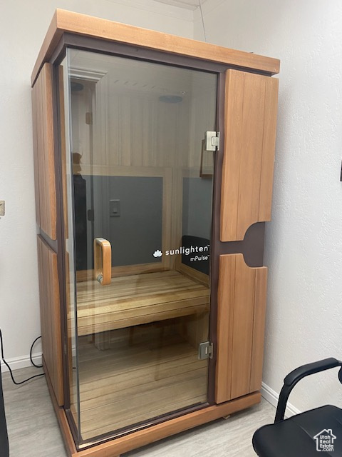 Relaxing sauna / steam room featuring baseboards and wood finished floors