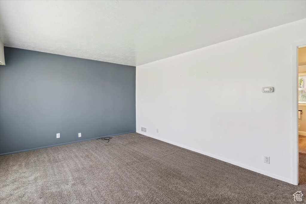 Carpeted empty room featuring baseboards