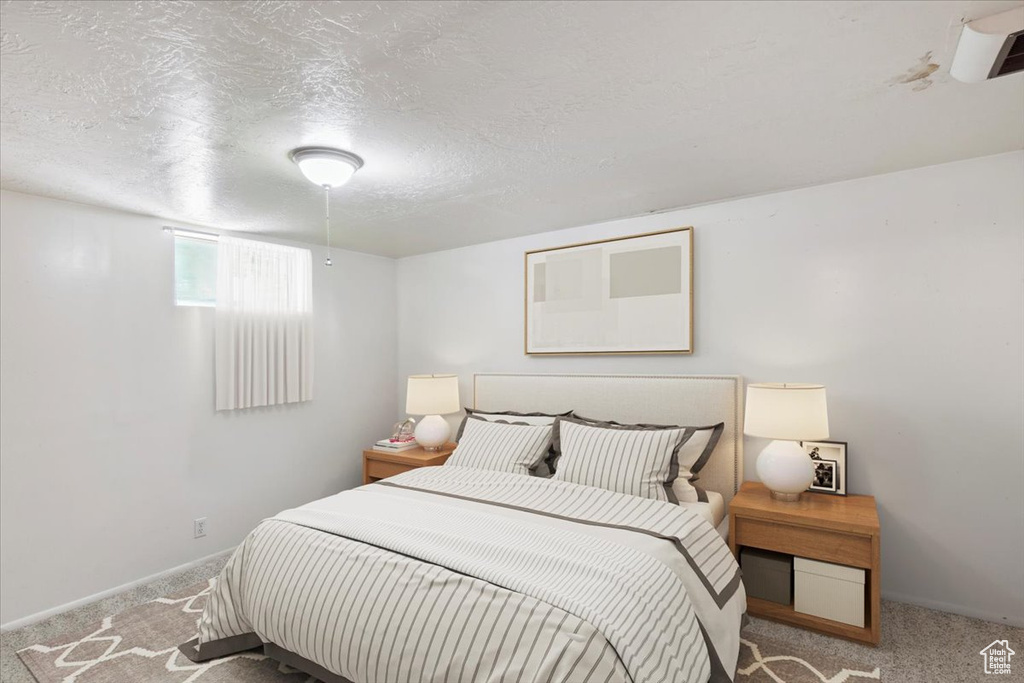 Bedroom featuring carpet floors, a textured ceiling, and baseboards