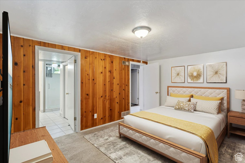 Bedroom featuring carpet and wood walls