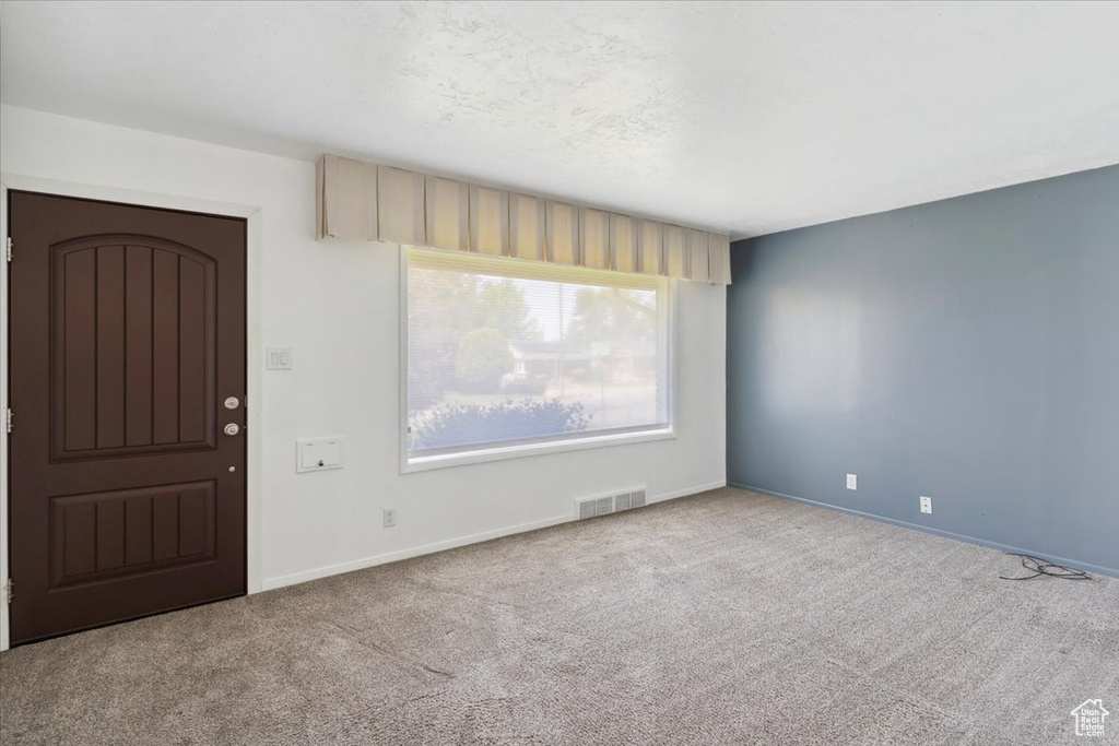 Entrance foyer featuring carpet flooring and baseboards