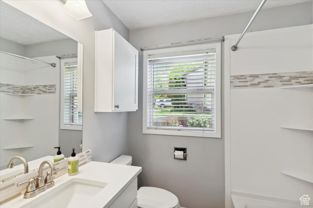 Full bath featuring a shower, toilet, and vanity
