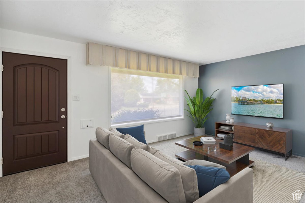 Carpeted living room featuring baseboards