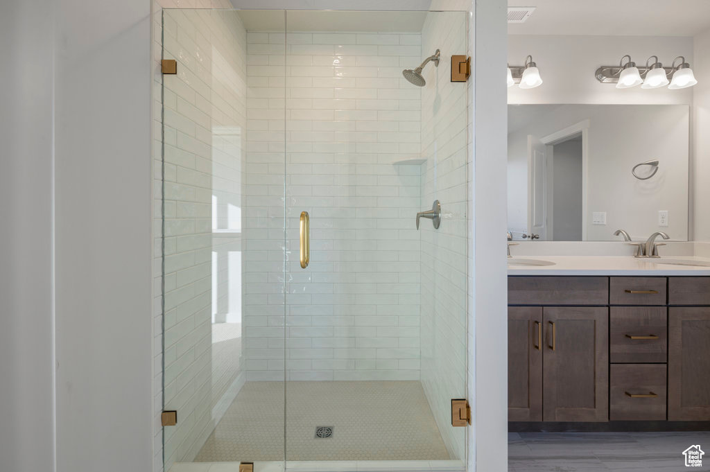 Bathroom featuring a stall shower and double vanity