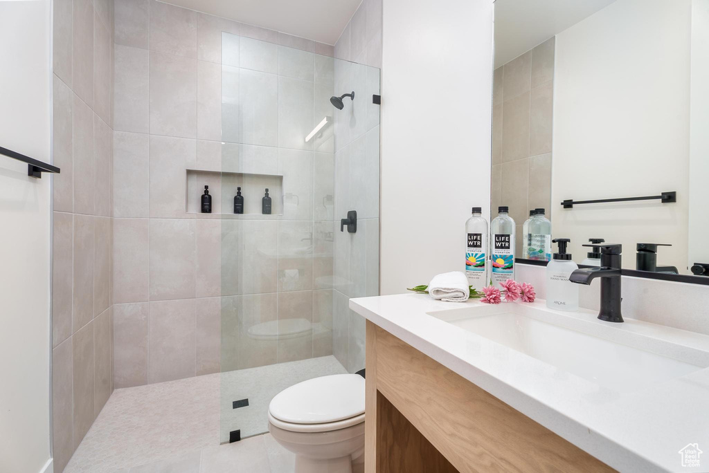 Full bathroom with toilet, vanity, and walk in shower