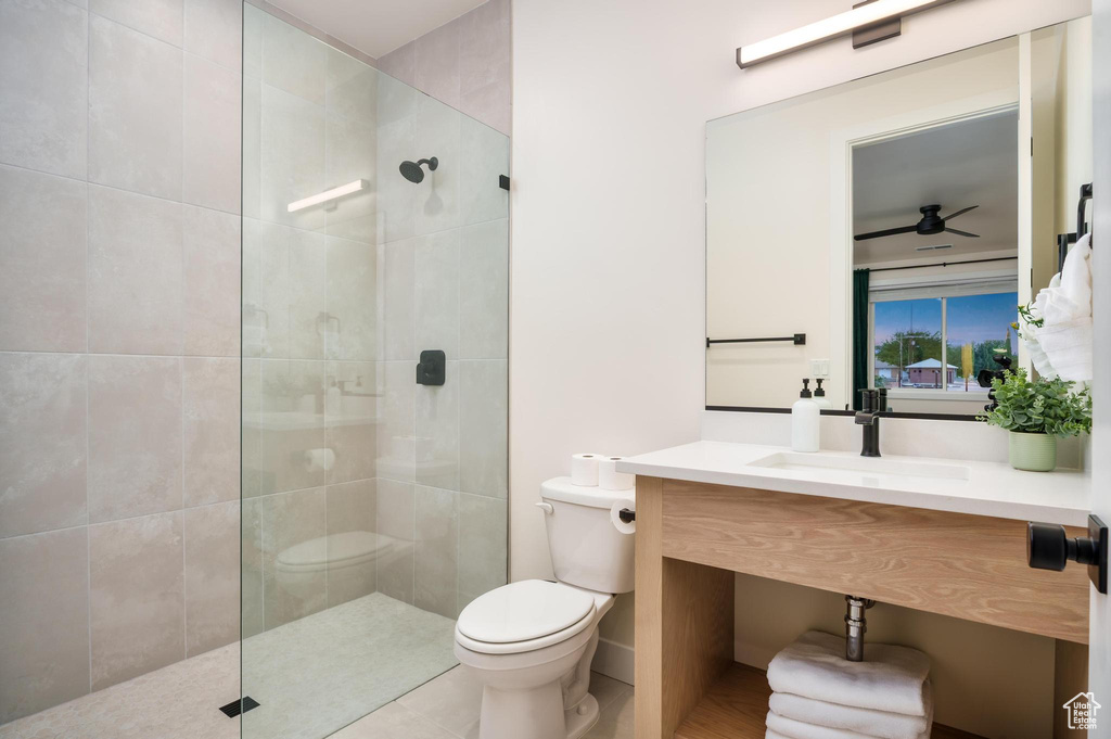 Full bath with toilet, walk in shower, vanity, and ceiling fan