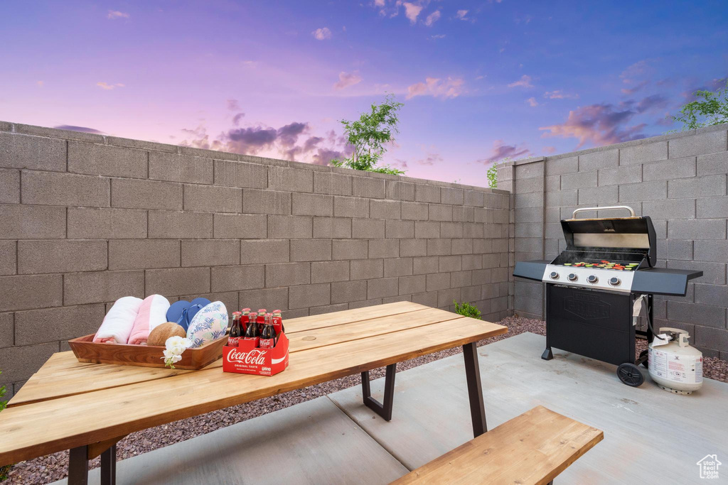 Patio terrace at dusk featuring a patio area and area for grilling
