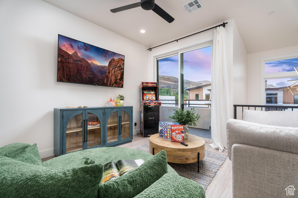 Living room with ceiling fan, healthy amount of natural light, wood finished floors, baseboards, and recessed lighting