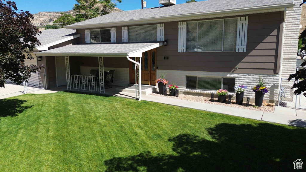 Rear view of property with a porch and a shingled roof