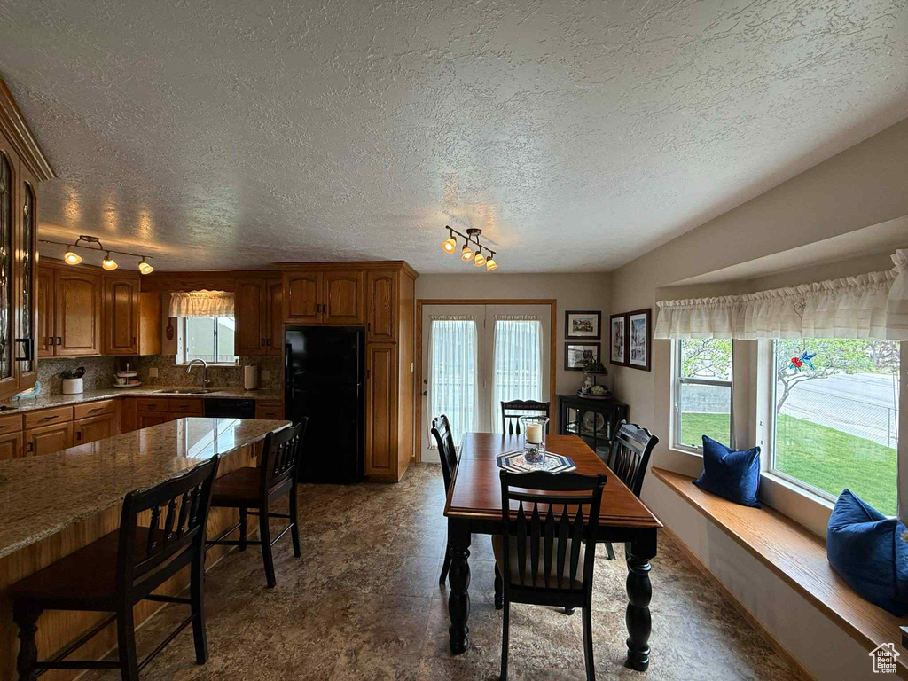 Dining space with a textured ceiling and track lighting