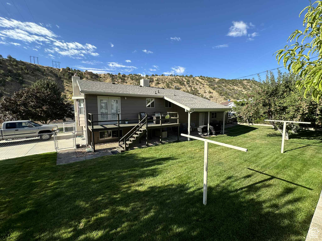 Rear view of house with stairs, a deck with mountain view, a chimney, and french doors