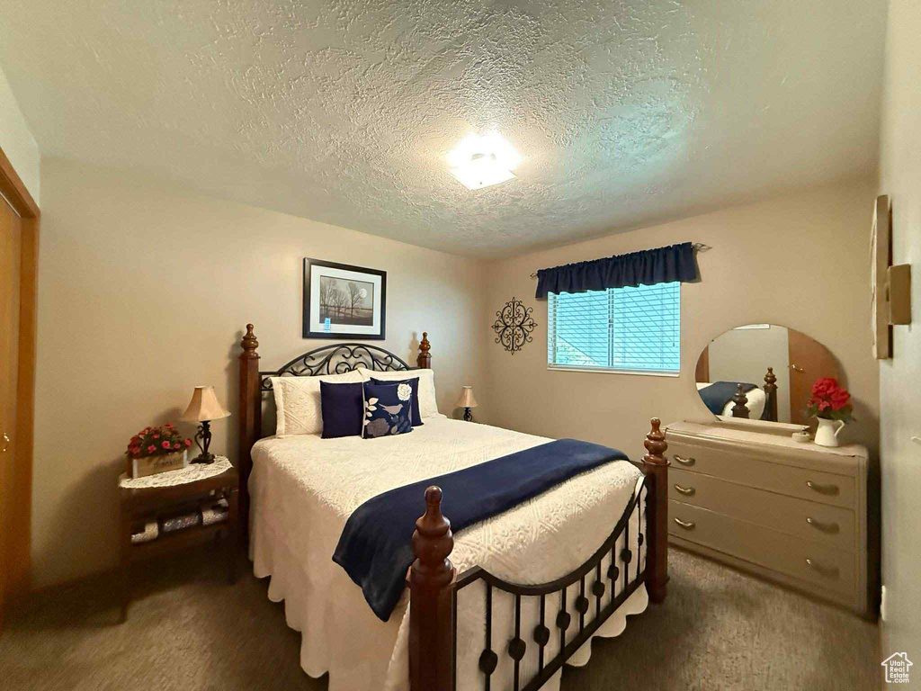 Carpeted bedroom with a textured ceiling