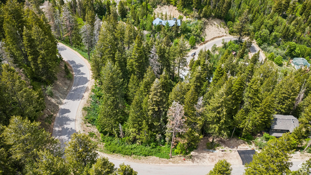 Aerial view of property and surrounding area featuring a forest