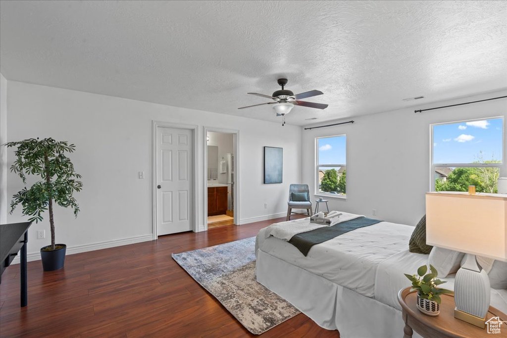 Bedroom featuring dark wood-type flooring, a textured ceiling, baseboards, and ceiling fan