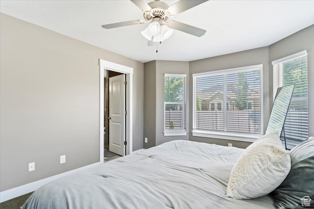 Carpeted bedroom with baseboards and a ceiling fan