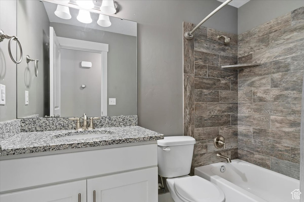 Bathroom featuring toilet, vanity, and bathtub / shower combination