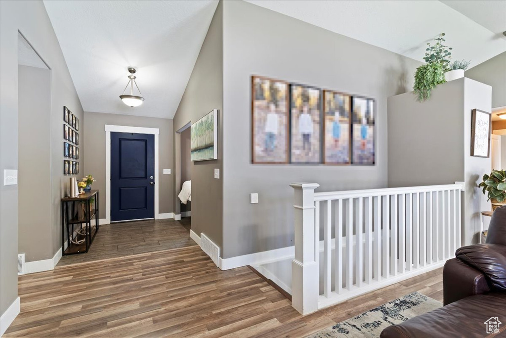 Entrance foyer with wood finished floors, lofted ceiling, and baseboards