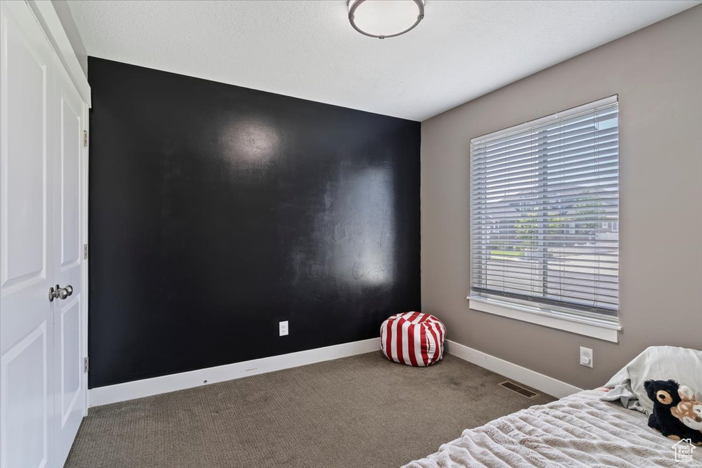 Bedroom featuring baseboards and carpet floors