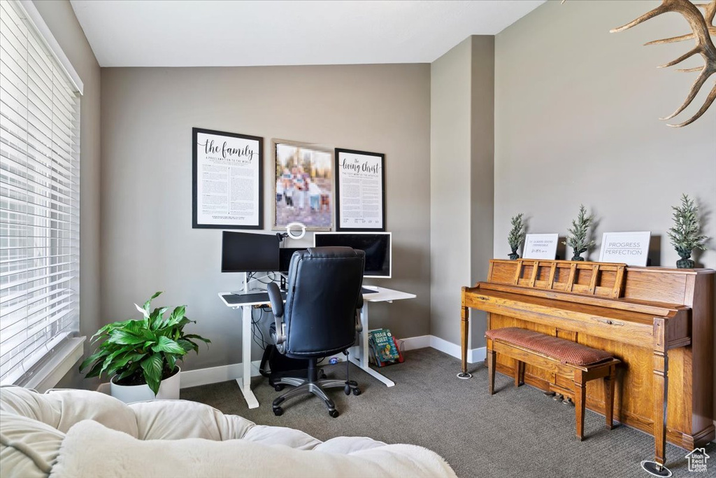 Carpeted office with vaulted ceiling and baseboards