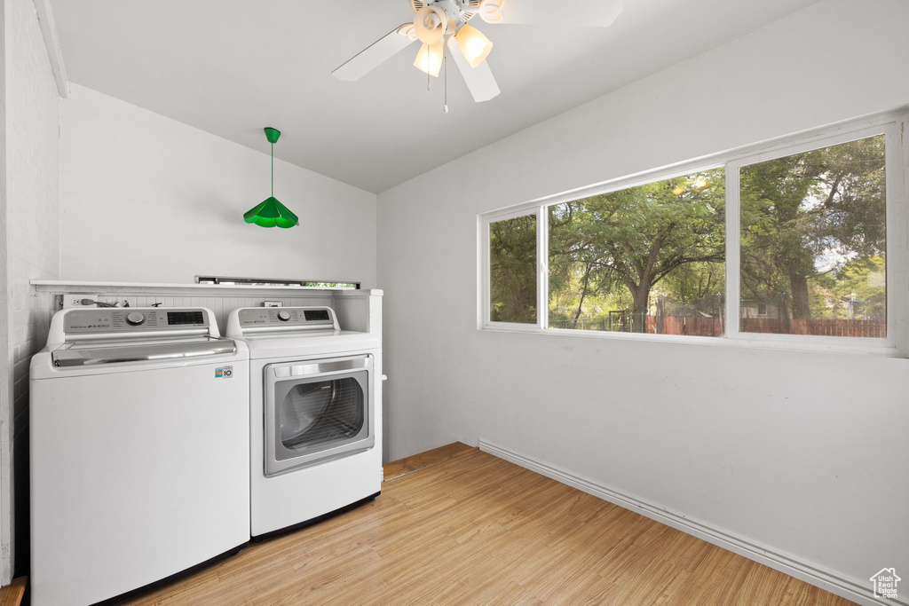 Laundry area with washing machine and dryer, light wood-style flooring, ceiling fan, and baseboards