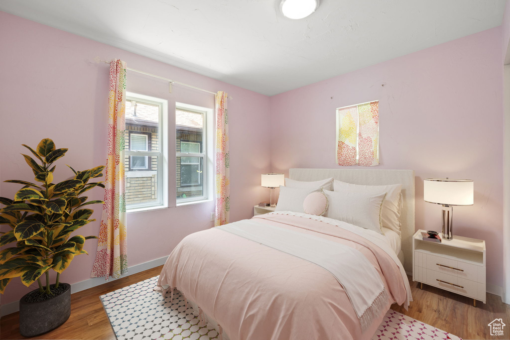 Bedroom with wood finished floors and baseboards
