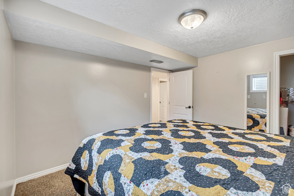 Carpeted bedroom with a textured ceiling