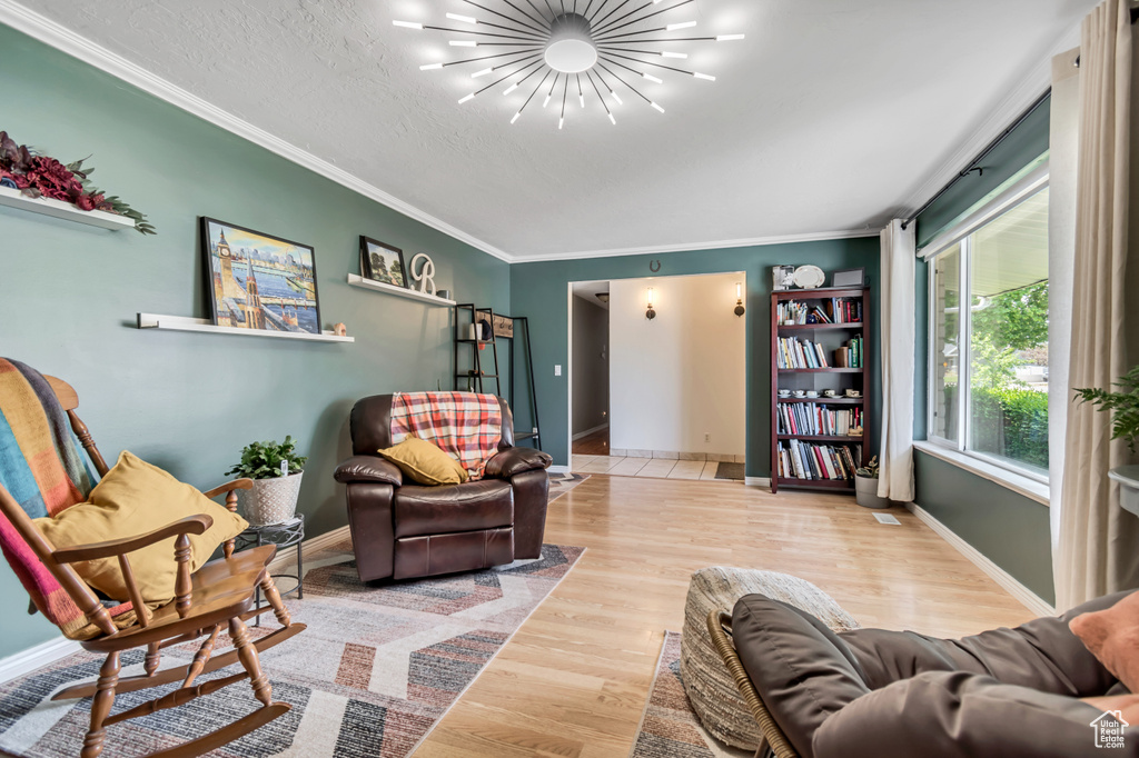 Living area featuring crown molding, wood finished floors, and baseboards