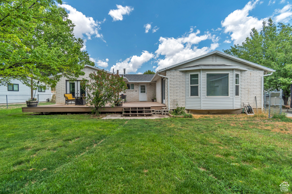 Rear view of house featuring a deck and brick siding