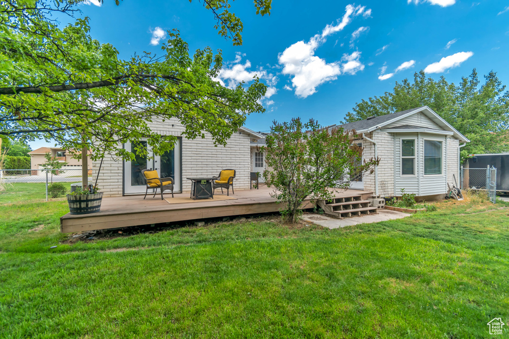 Rear view of house featuring a deck and brick siding