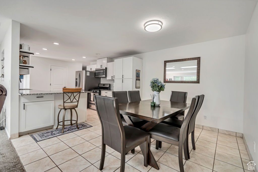 Dining space with light tile patterned floors, recessed lighting, and baseboards