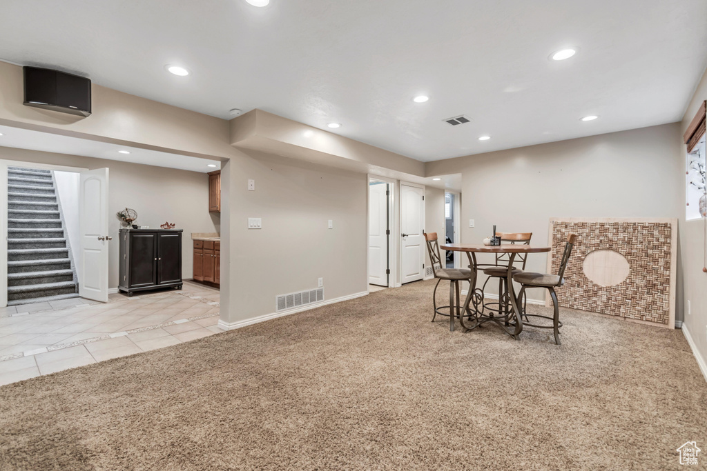 Dining area with recessed lighting, baseboards, stairs, light carpet, and light tile patterned flooring