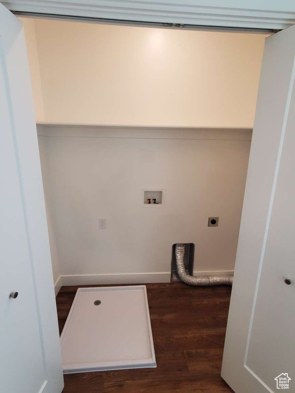 Washroom with hookup for an electric dryer, wood finished floors, baseboards, and washer hookup