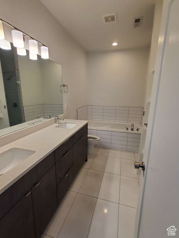 Bathroom with double vanity, a garden tub, tile patterned flooring, toilet, and a stall shower