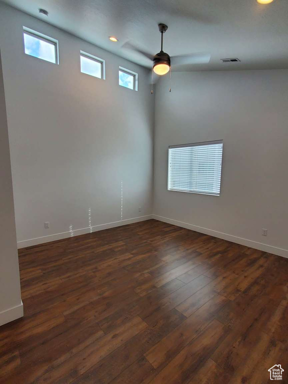 Unfurnished room with dark wood finished floors, baseboards, and ceiling fan
