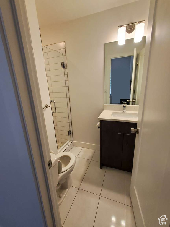 Full bathroom featuring toilet, tile patterned floors, a shower stall, vanity, and baseboards