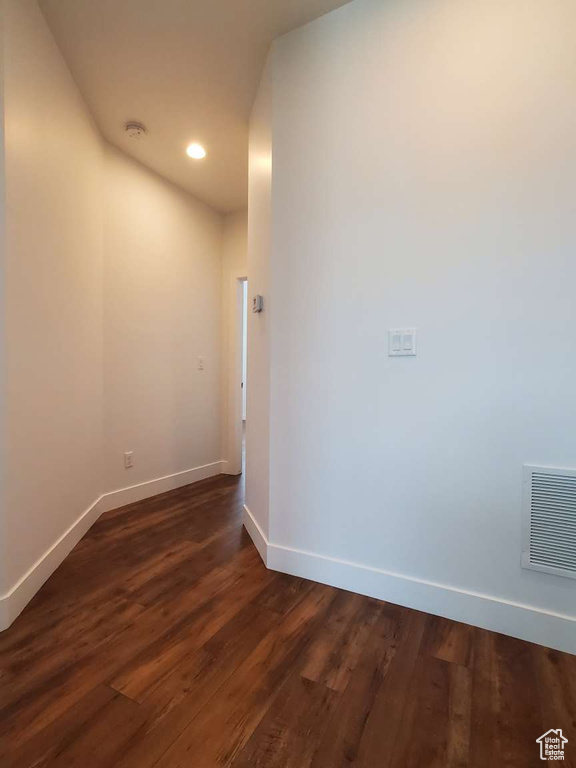 Empty room featuring baseboards, dark wood-type flooring, recessed lighting, and a smoke detector
