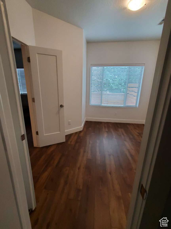 Hall with dark wood-style floors and baseboards